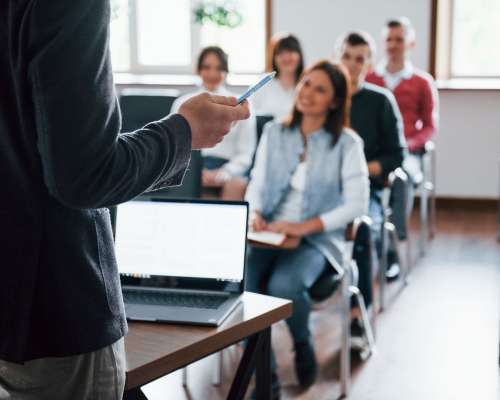 Everyone is smiling and listens. Group of people at business conference in modern classroom at daytime Everyone is smiling and listens. Group of people at business conference in modern classroom at daytime.